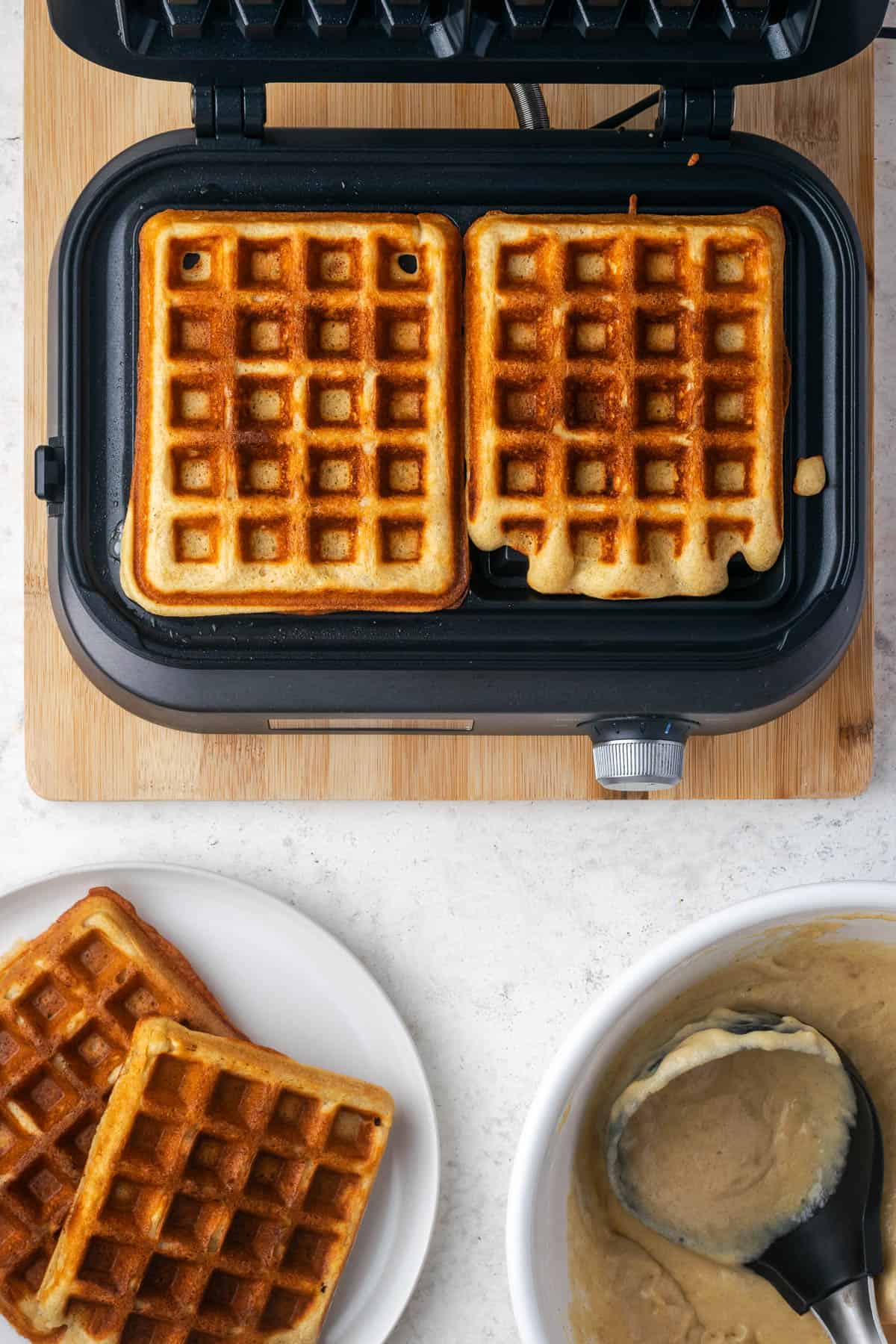 Gluten free banana waffles cooking in a waffle iron. 