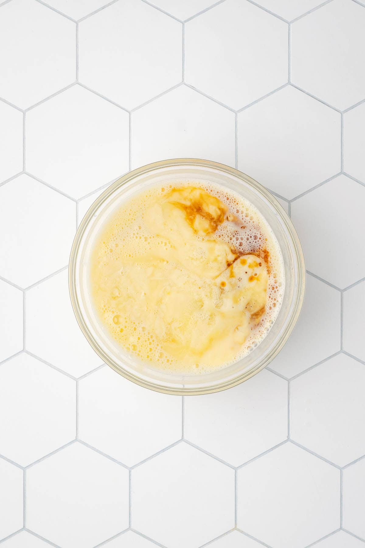 Milk, melted butter and vanilla extract poured into the bowl with the beaten egg.