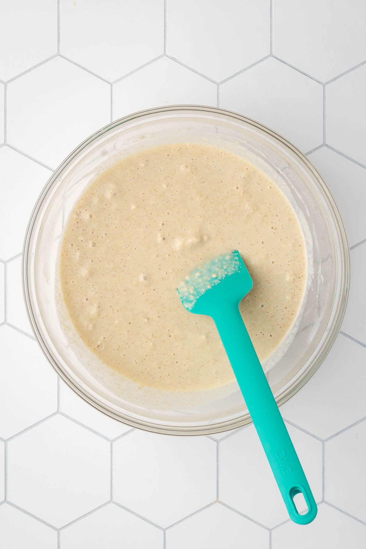 A bowl of pancake batter sitting on a tile counter.