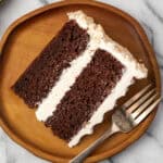 A slice of chocolate coconut cake served on a wooden plate.