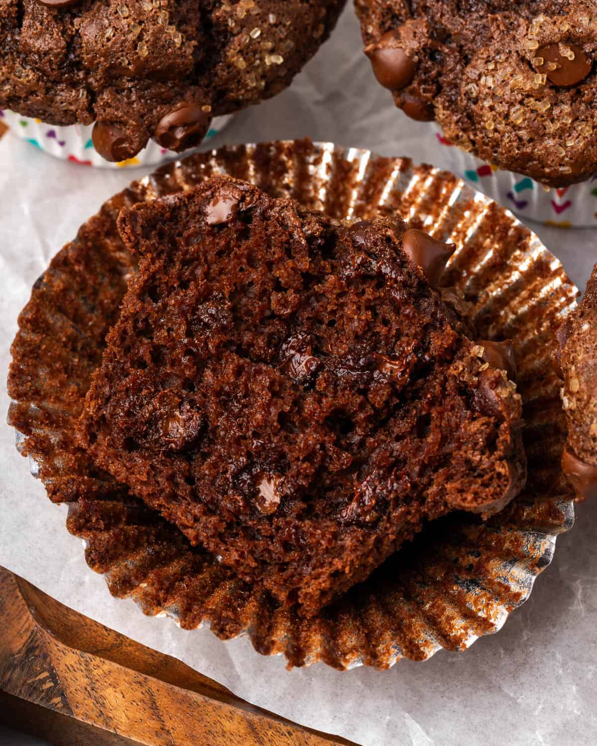 A gluten free chocolate muffin cut open showing the melted chocolate chips inside. 