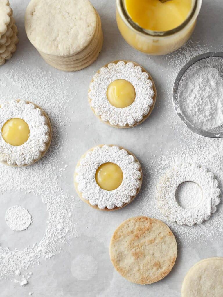 Several gluten free lemon linzer cookies sitting on a counter.