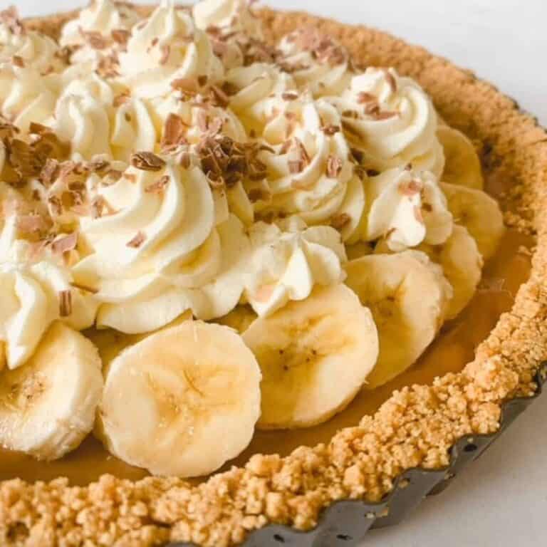 A gluten free banoffee pie topped with whipped cream and fresh bananas.