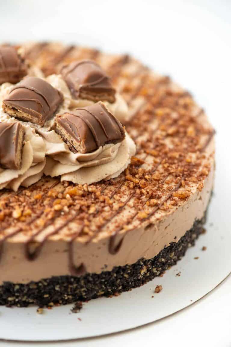 A Nutella cheesecake topped with chocolate and chopped nuts.