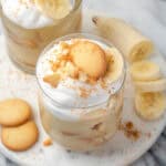 Two glasses of gluten free banana pudding sitting on a marble tray.