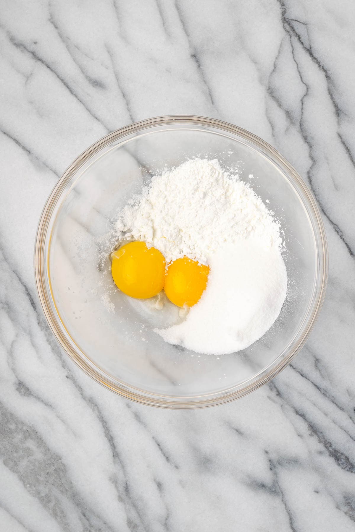 Egg yolks, cornstarch and sugar combined in a large glass mixing bowl. 