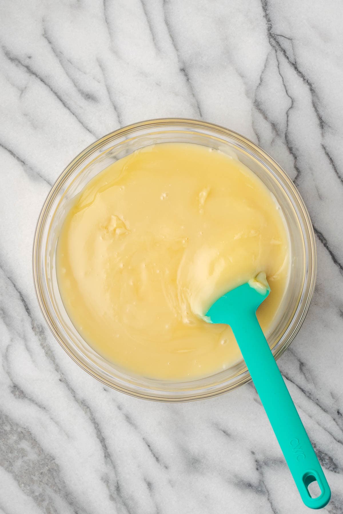 Sweetened condensed milk being stirred into the vanilla pudding. 