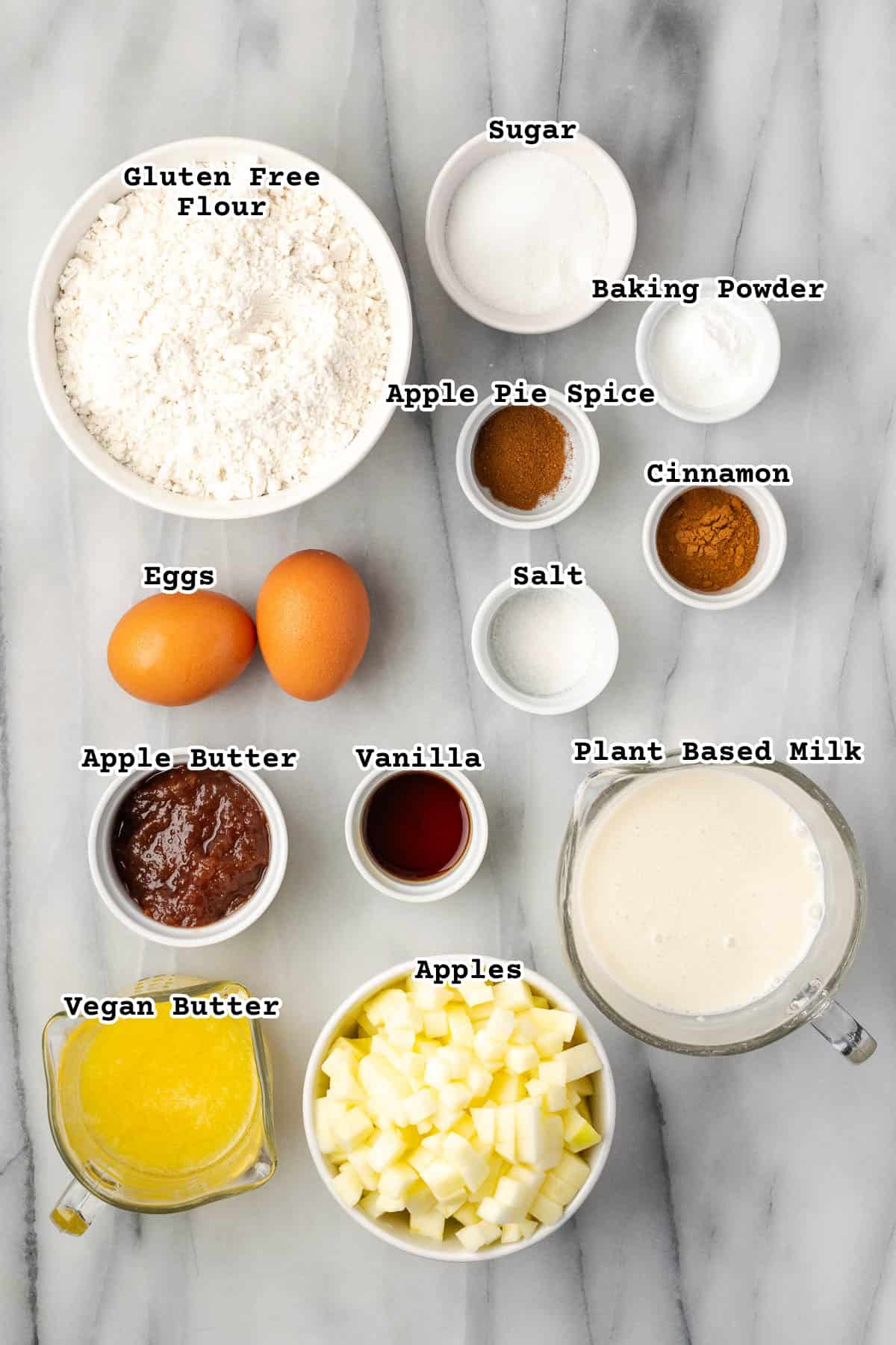 Ingredients for apple cinnamon waffles on a marble countertop. 