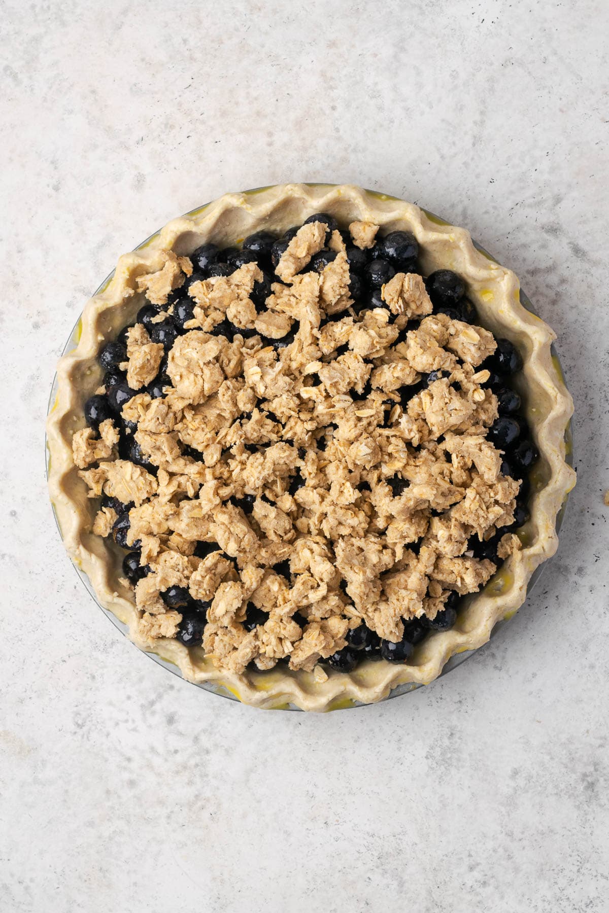 Crumble topping spread over the blueberry pie filling.