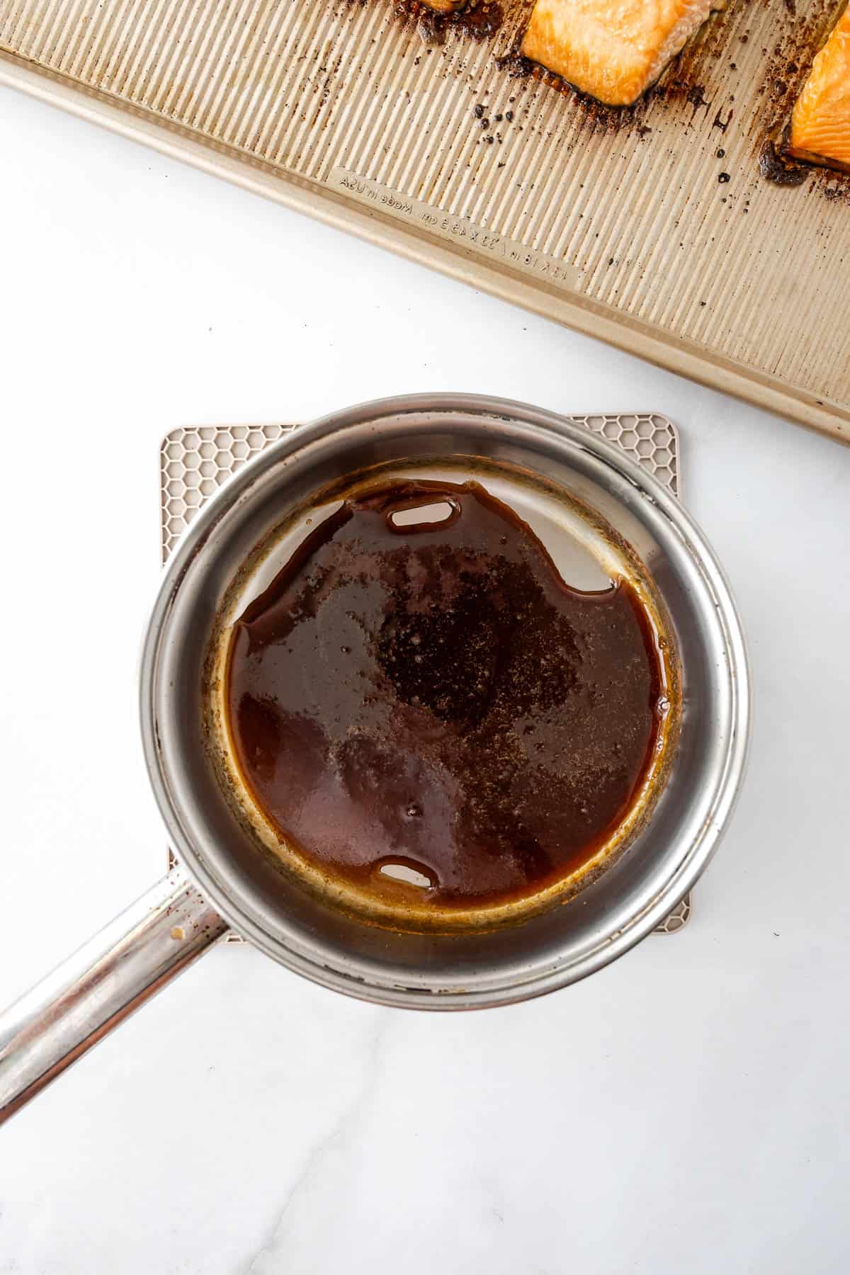Teriyaki sauce being heated in a small saucepan.