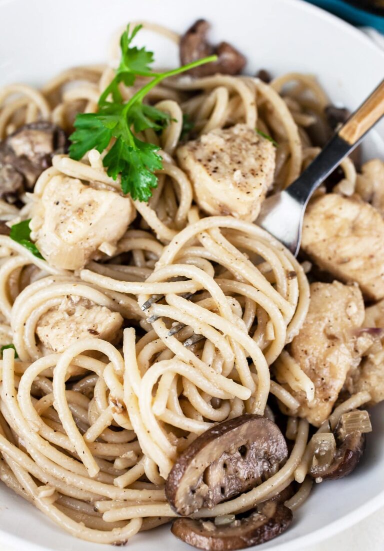 A bowl of gluten free spaghetti with chicken and mushrooms.