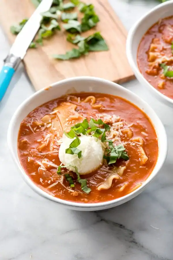 Gluten free lasagna soup in a serving bowl sitting on a marble counter.