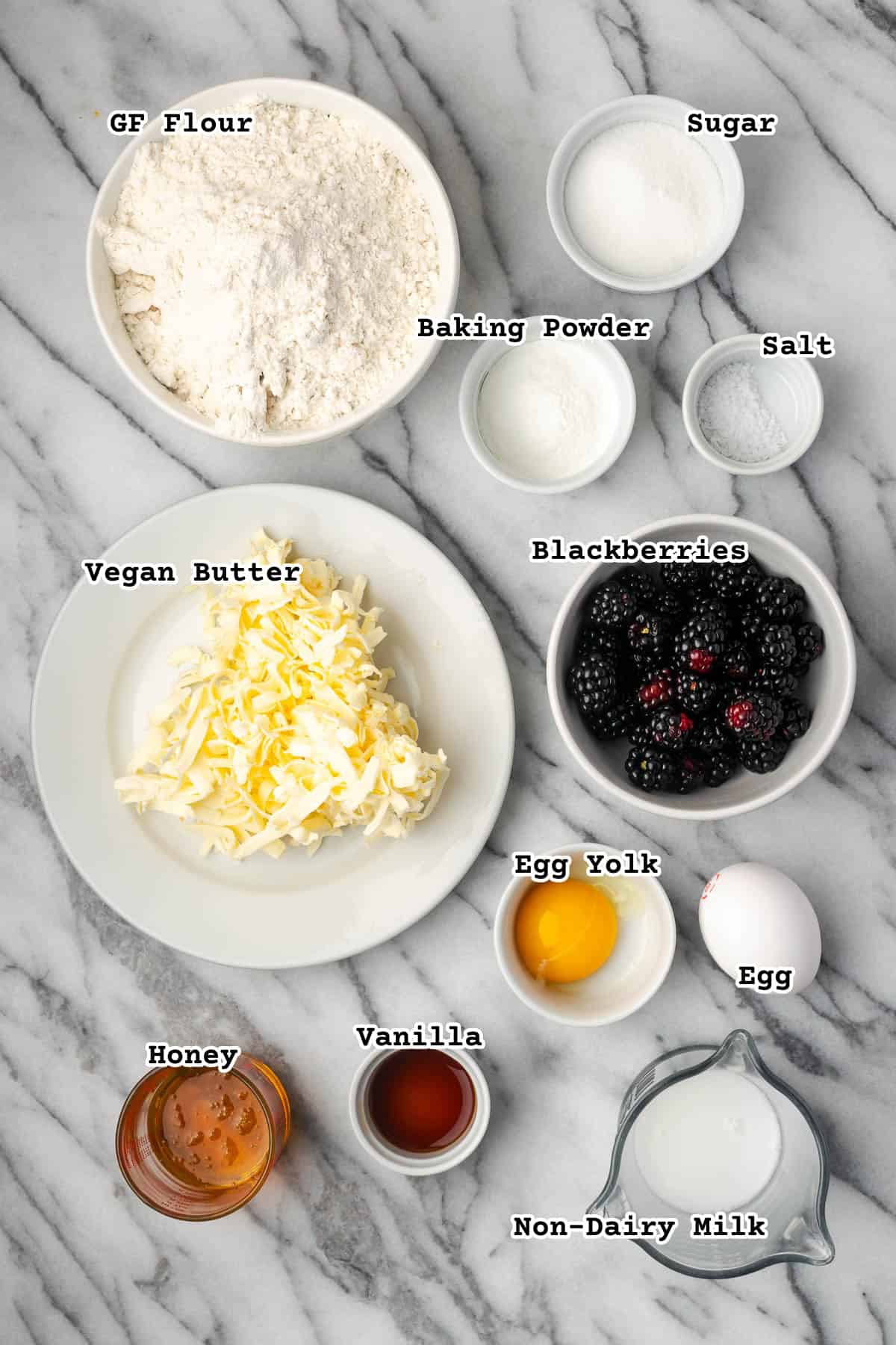 Ingredients for blackberry scones on a marble counter.