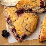 Several blackberry scones sitting on a wooden tray.