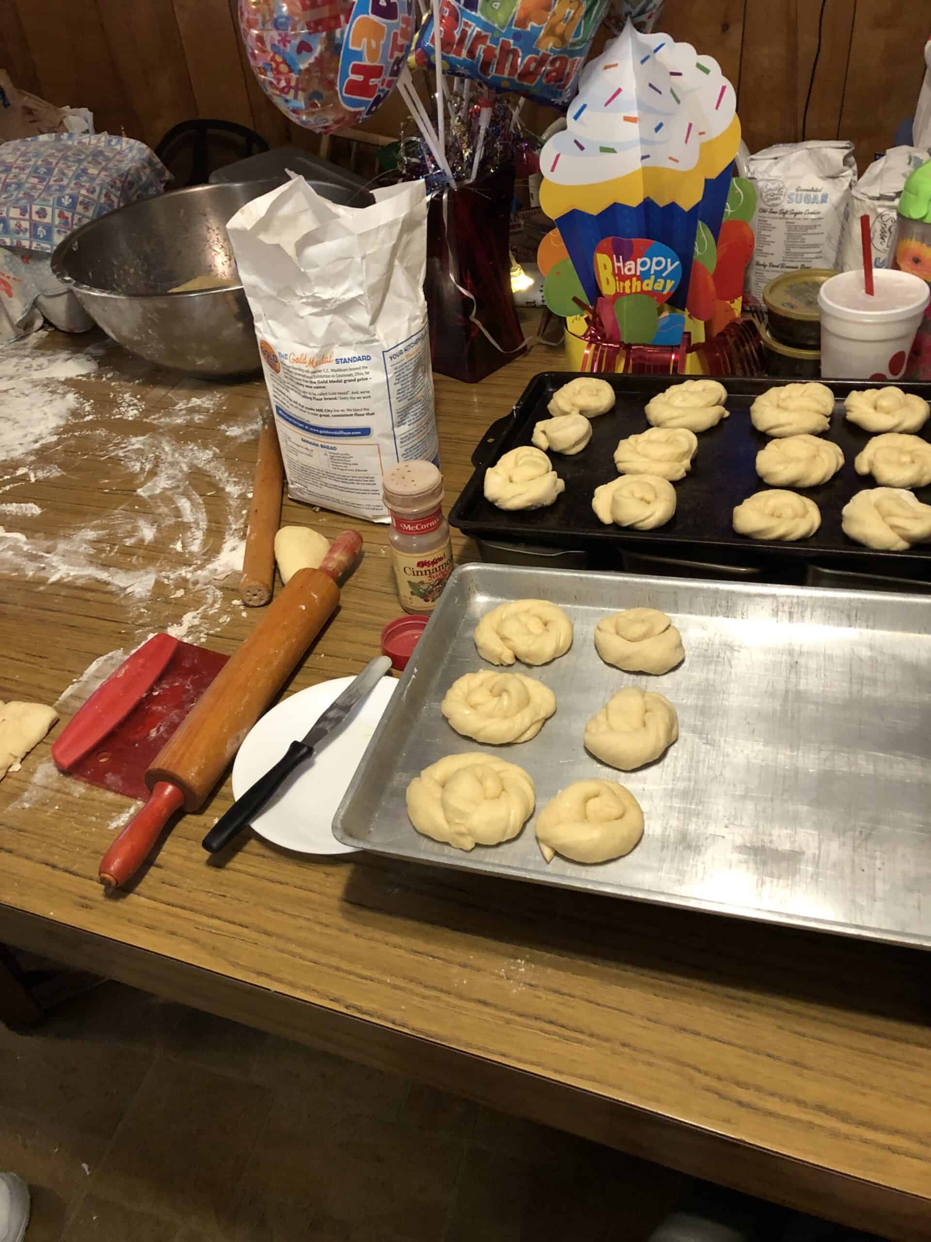 Unbaked butter rolls sitting on two baking sheets.
