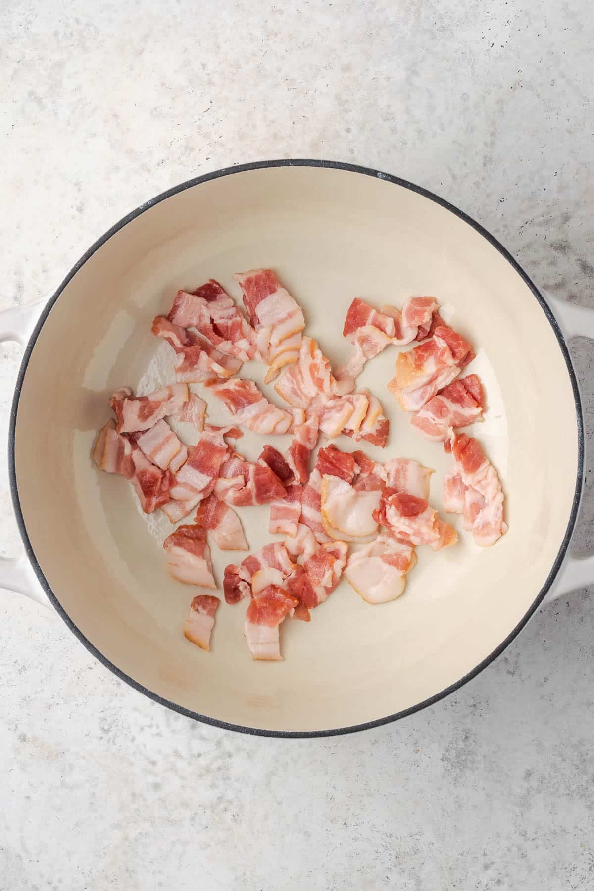 Uncooked bacon in a Dutch oven pot.