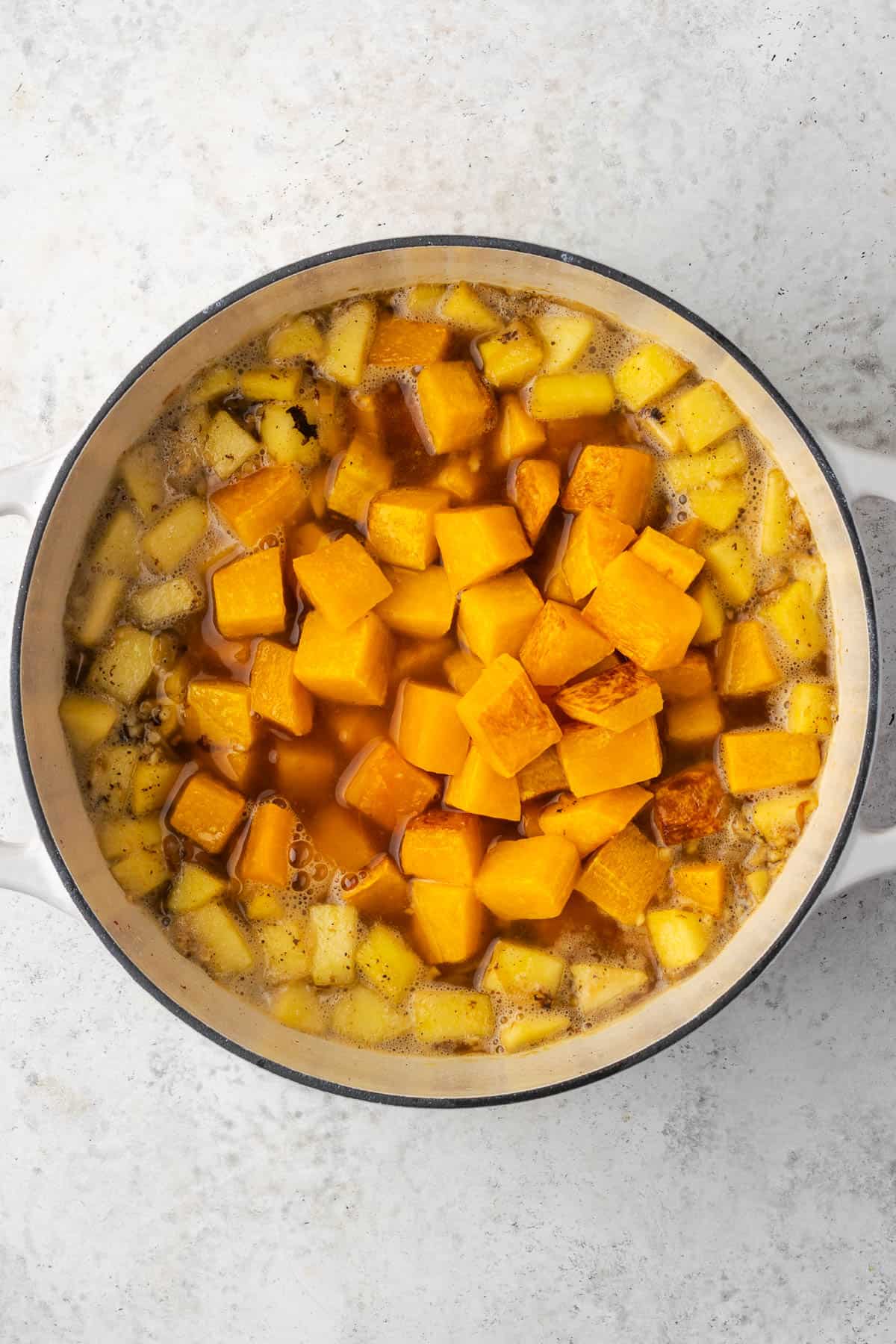 Squash and apples added into the soup pot.