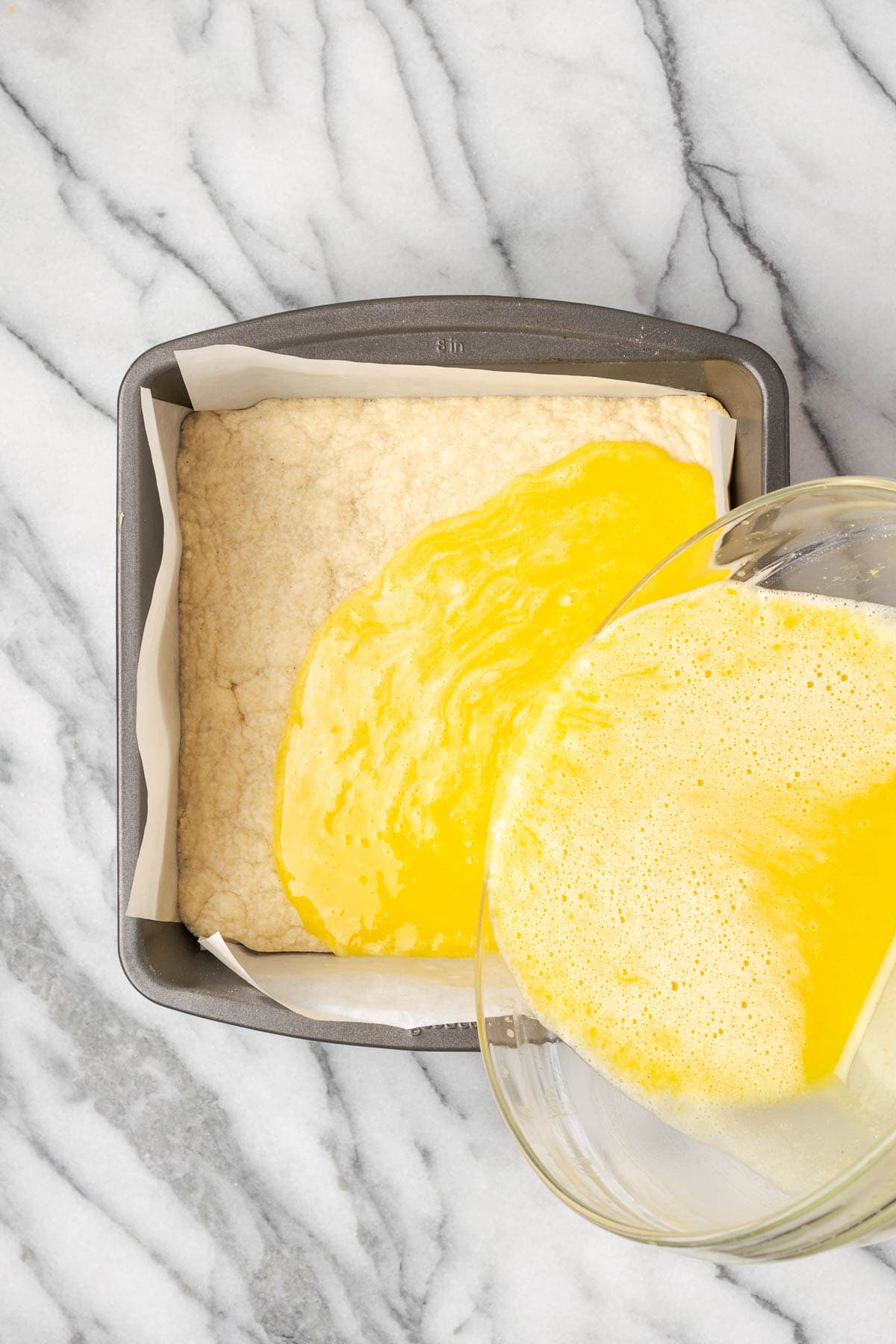 Lemon filling being poured over a partially baked crust.
