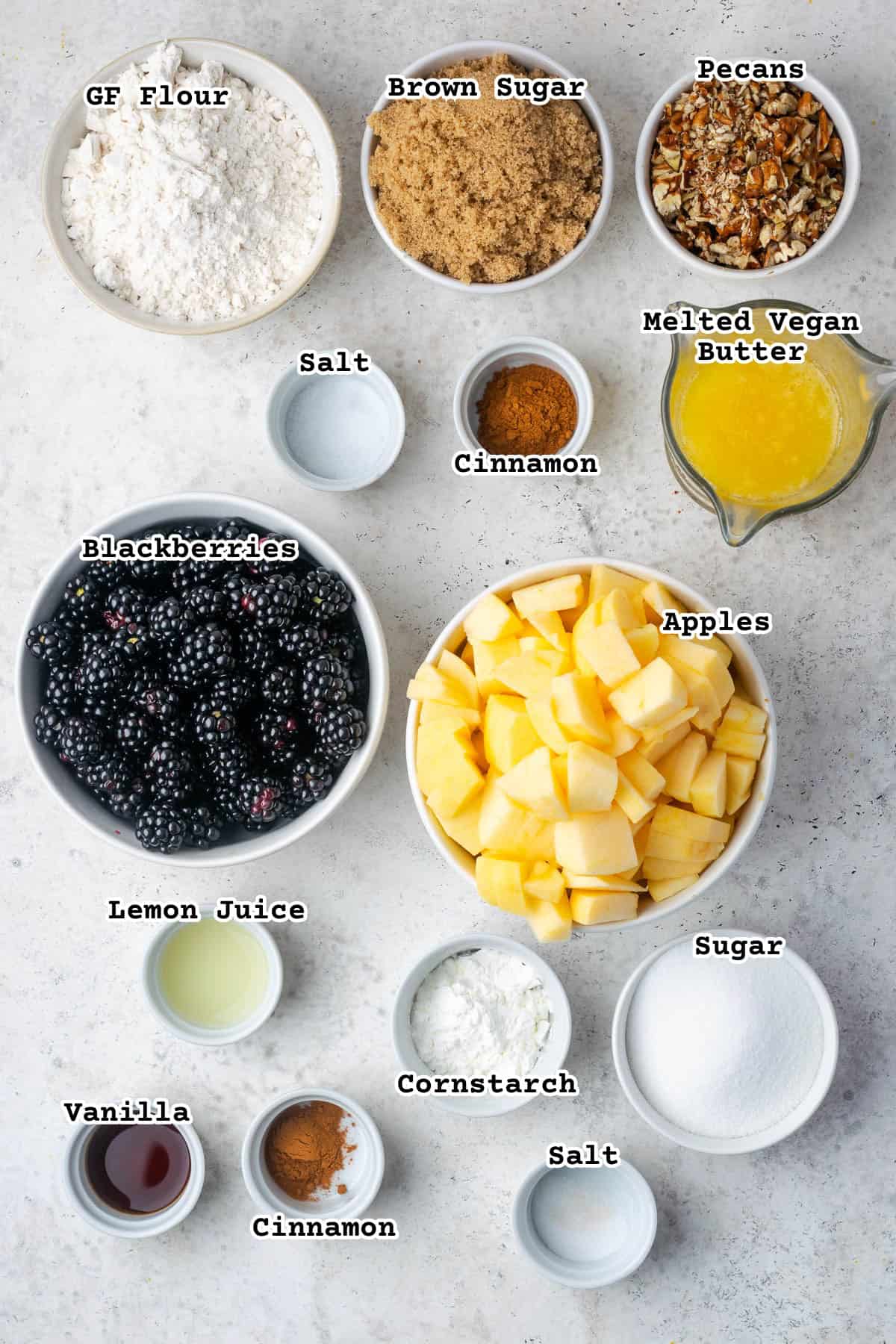 Ingredients for an apple and blackberry crumble sitting on a white counter.
