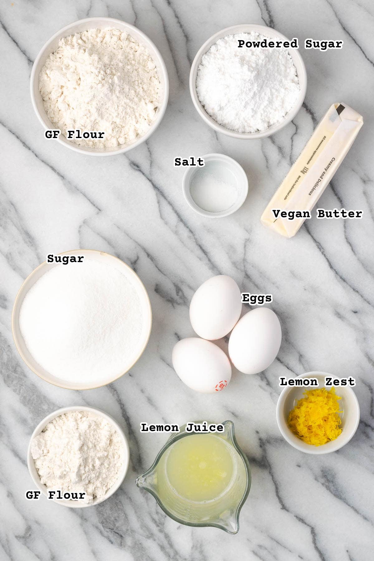 Ingredients for gluten free lemon bars on a marble counter.