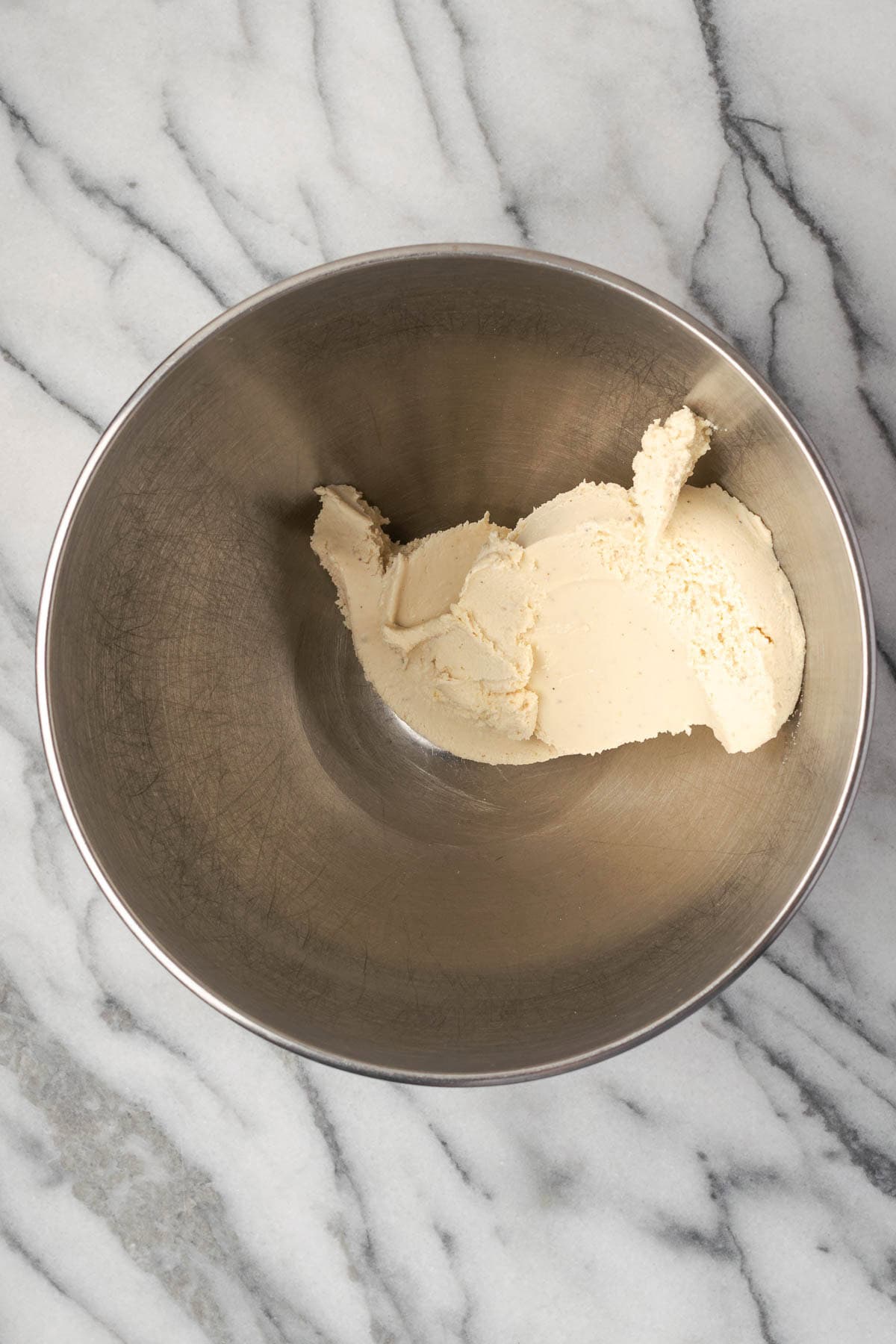 Cream cheese in a large metal mixing bowl.