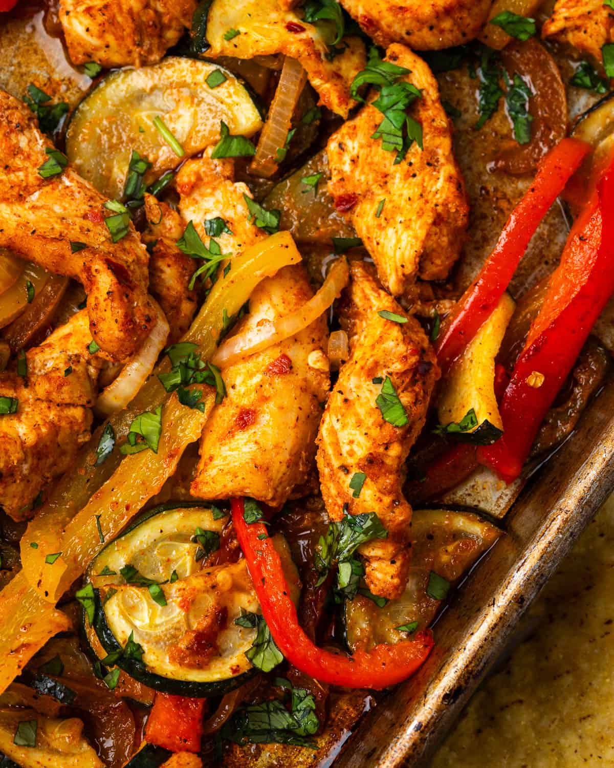 Freshly baked chicken fajitas on a metal sheet pan. 