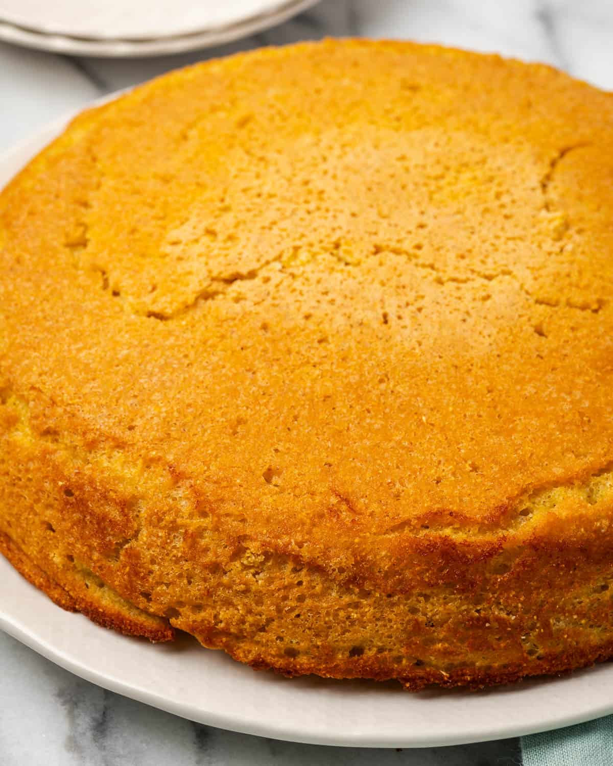 A freshly baked batch of cornbread on a large serving plate.
