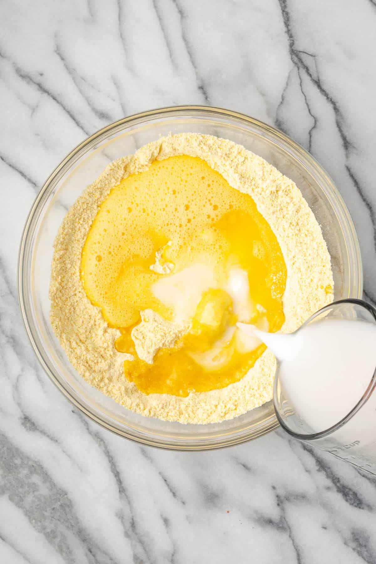 Melted butter, sour milk and beaten eggs added to the bowl of dry ingredients.