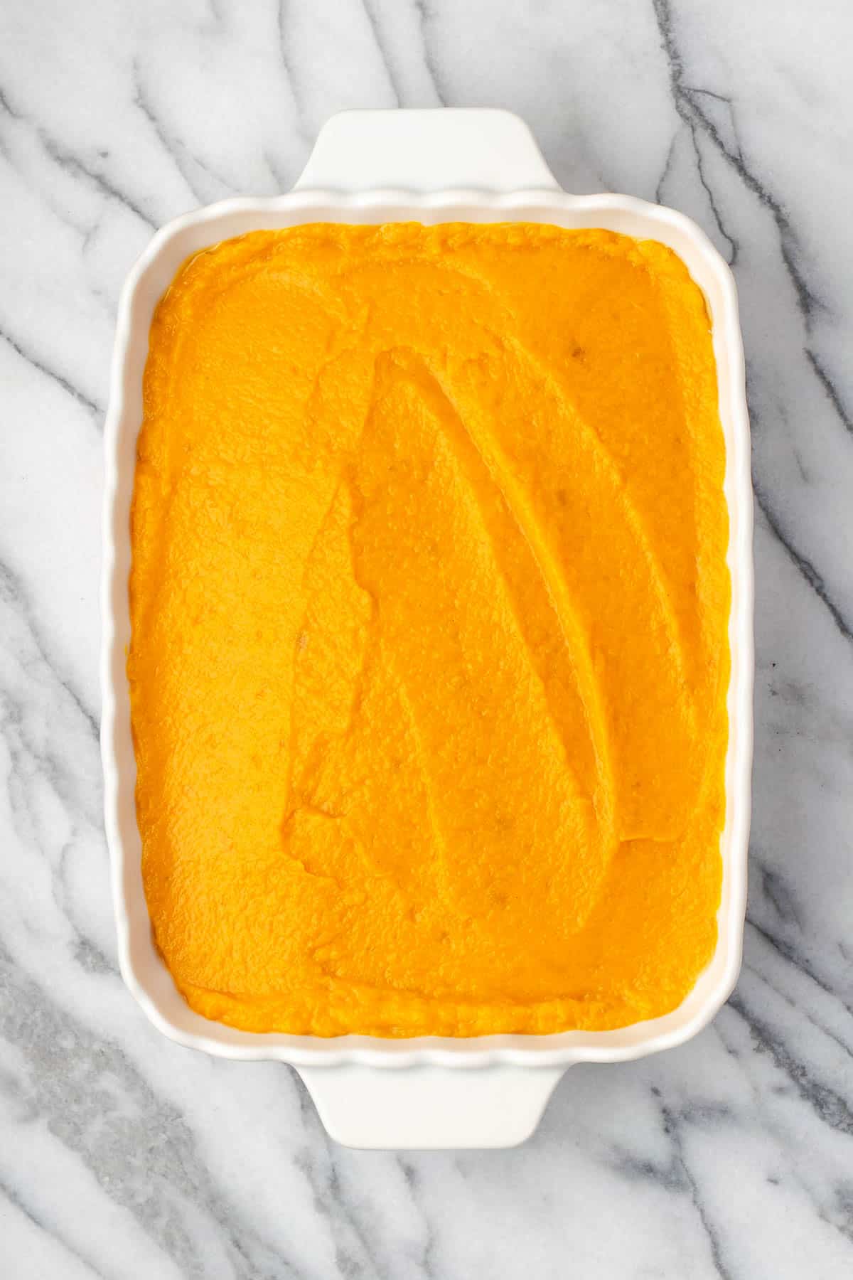 Sweet potato filling spread in a casserole dish.