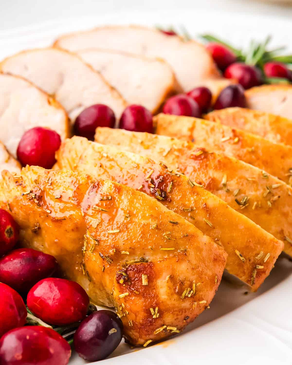 A cooked turkey tenderloin cut into slices on a serving tray.