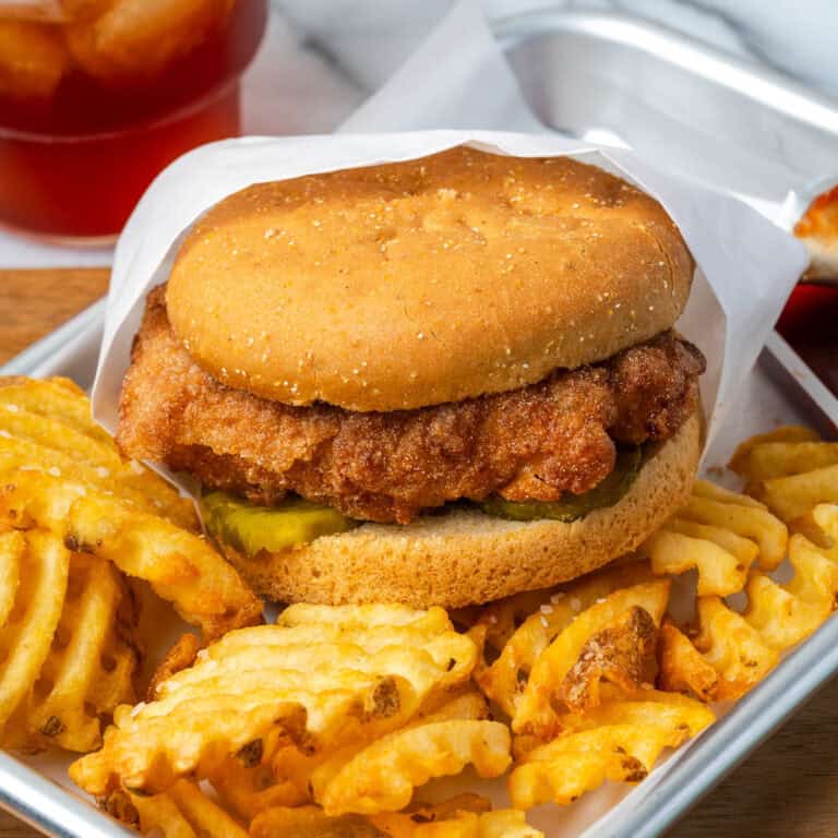 A homemade chick fil a chicken sandwich served with waffle fries.