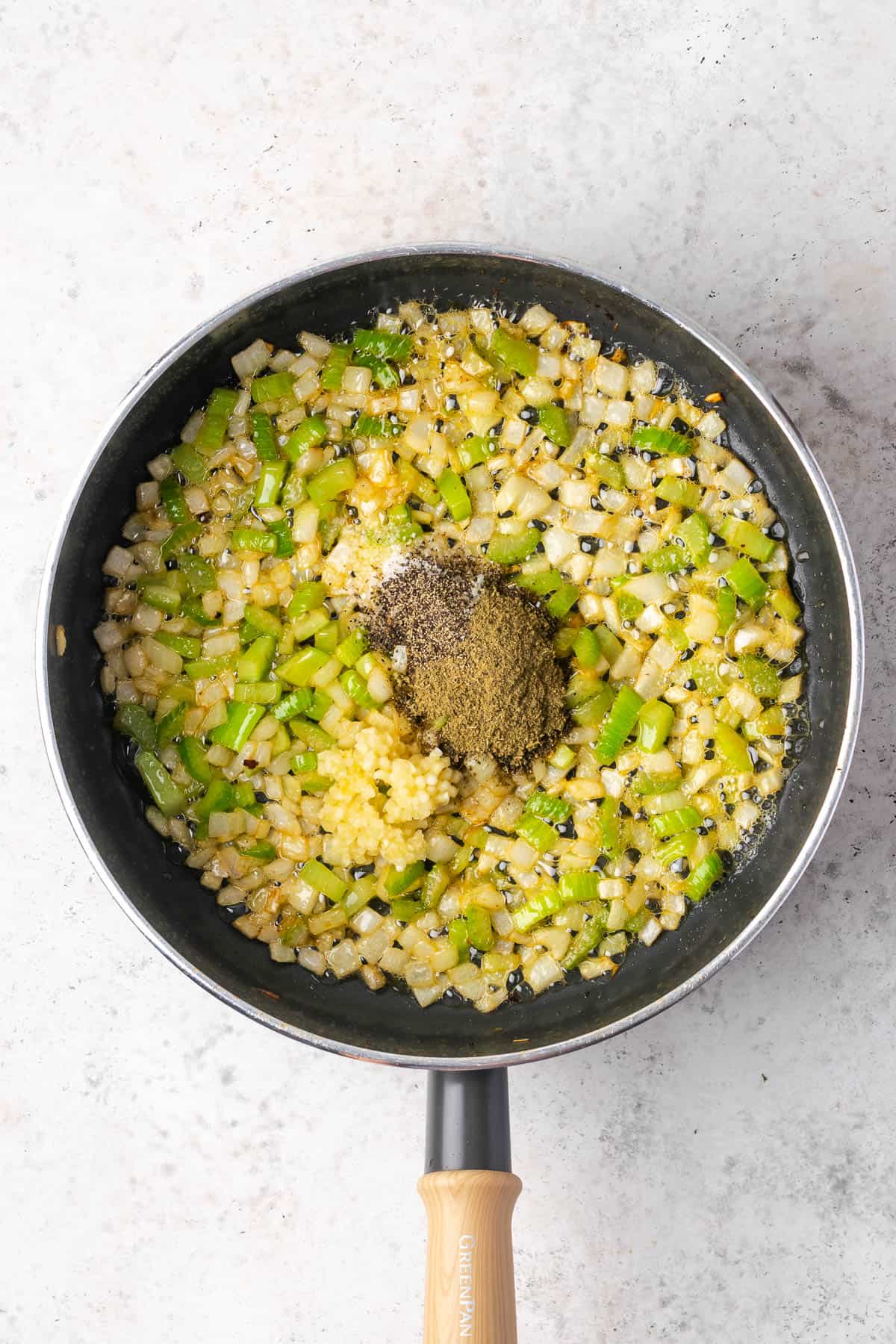 Minced garlic, herbs and spices added to the skillet with the cooked vegetables.