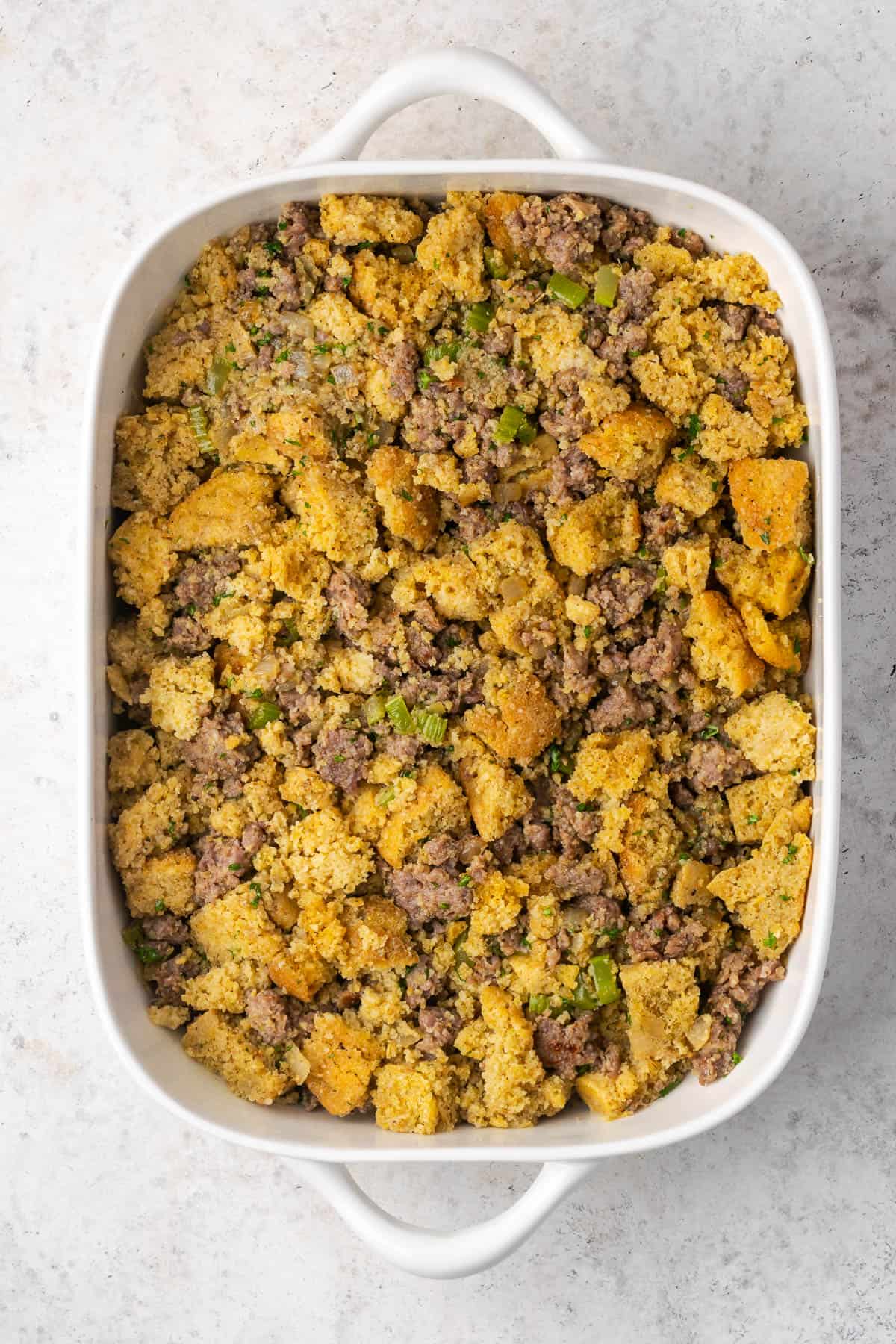 Cornbread stuffing spread out in a large baking dish.