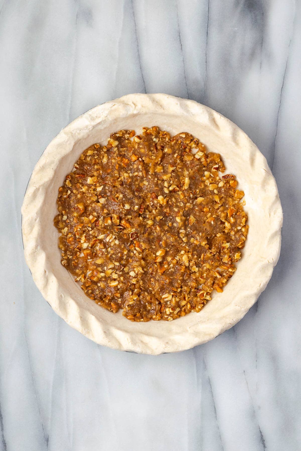 Pecan praline pressed into the bottom of an unbaked pie shell. 