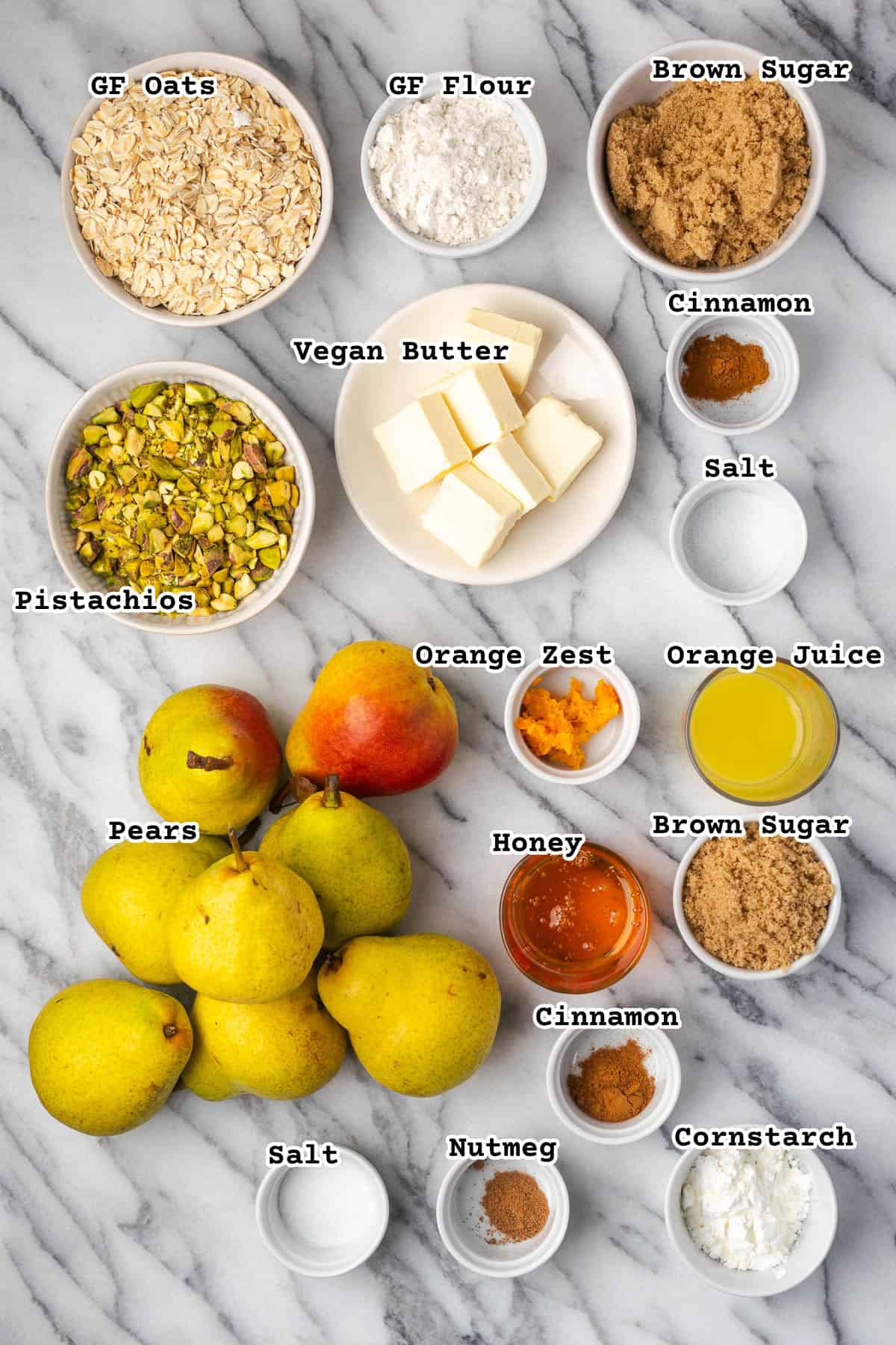 Ingredients for a pear crumble pie on a marble counter.
