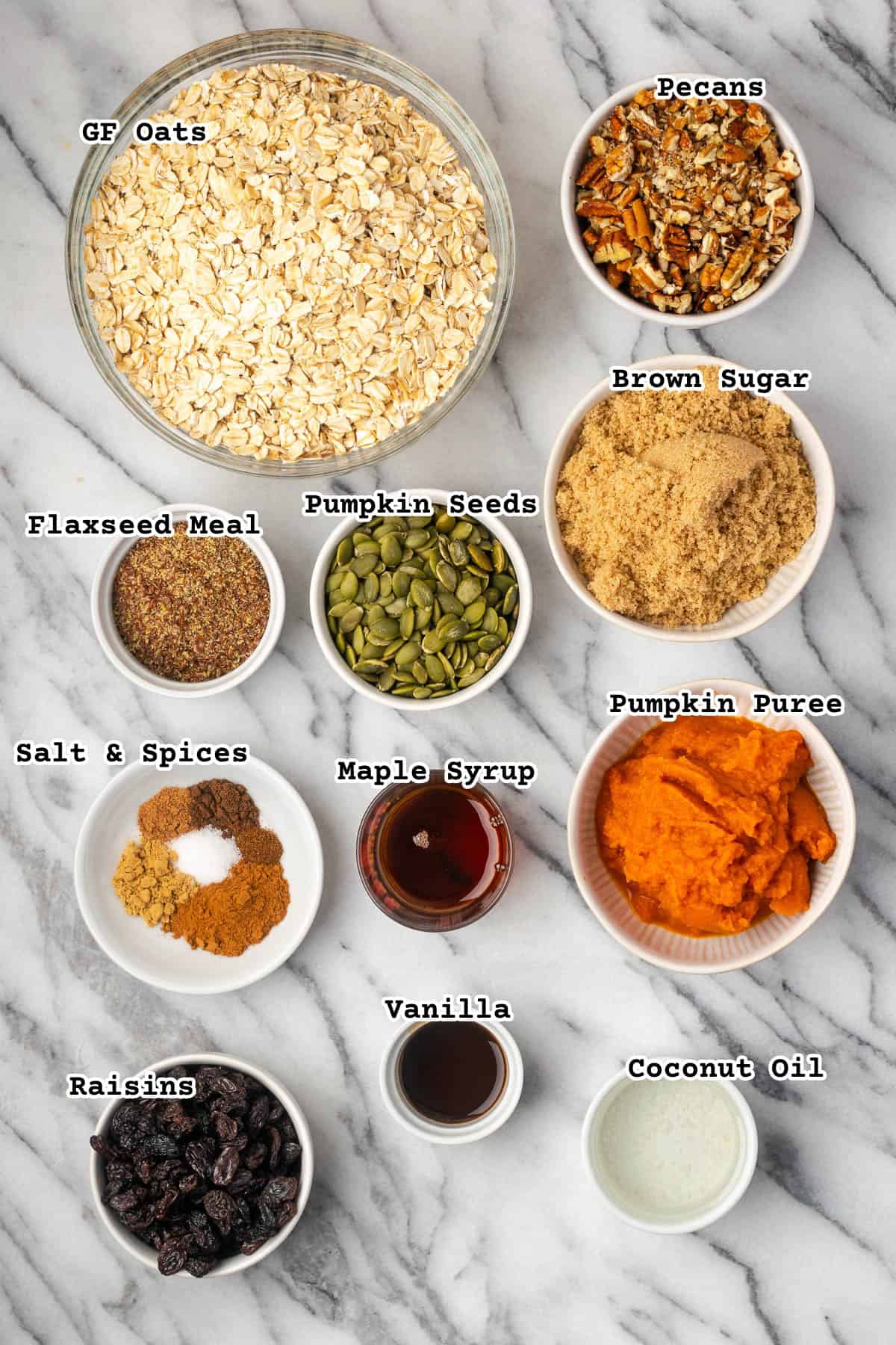 Ingredients for pumpkin seed granola on a marble counter. 