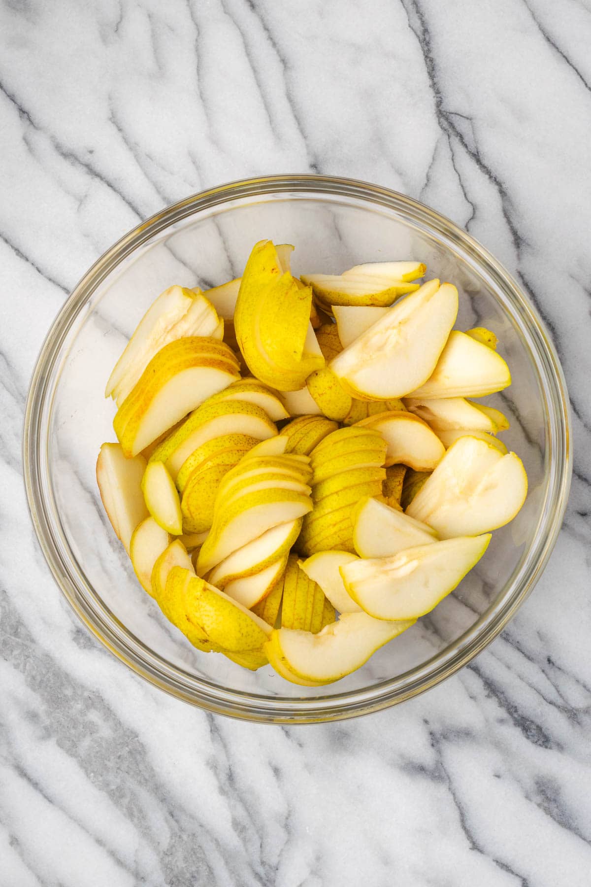 Sliced pears in a large mixing bowl. 