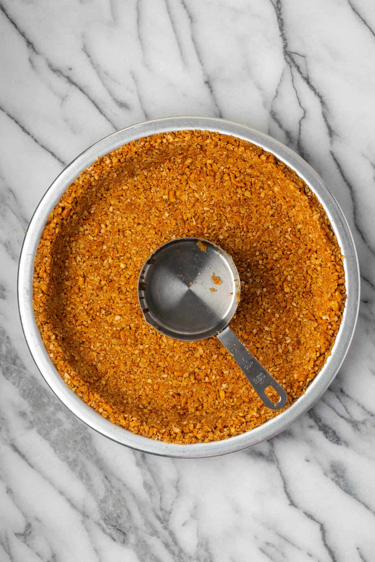 Pretzel mixture pressed into a metal pie plate.