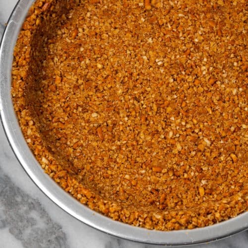 A pretzel pie crust in a metal pie tin.