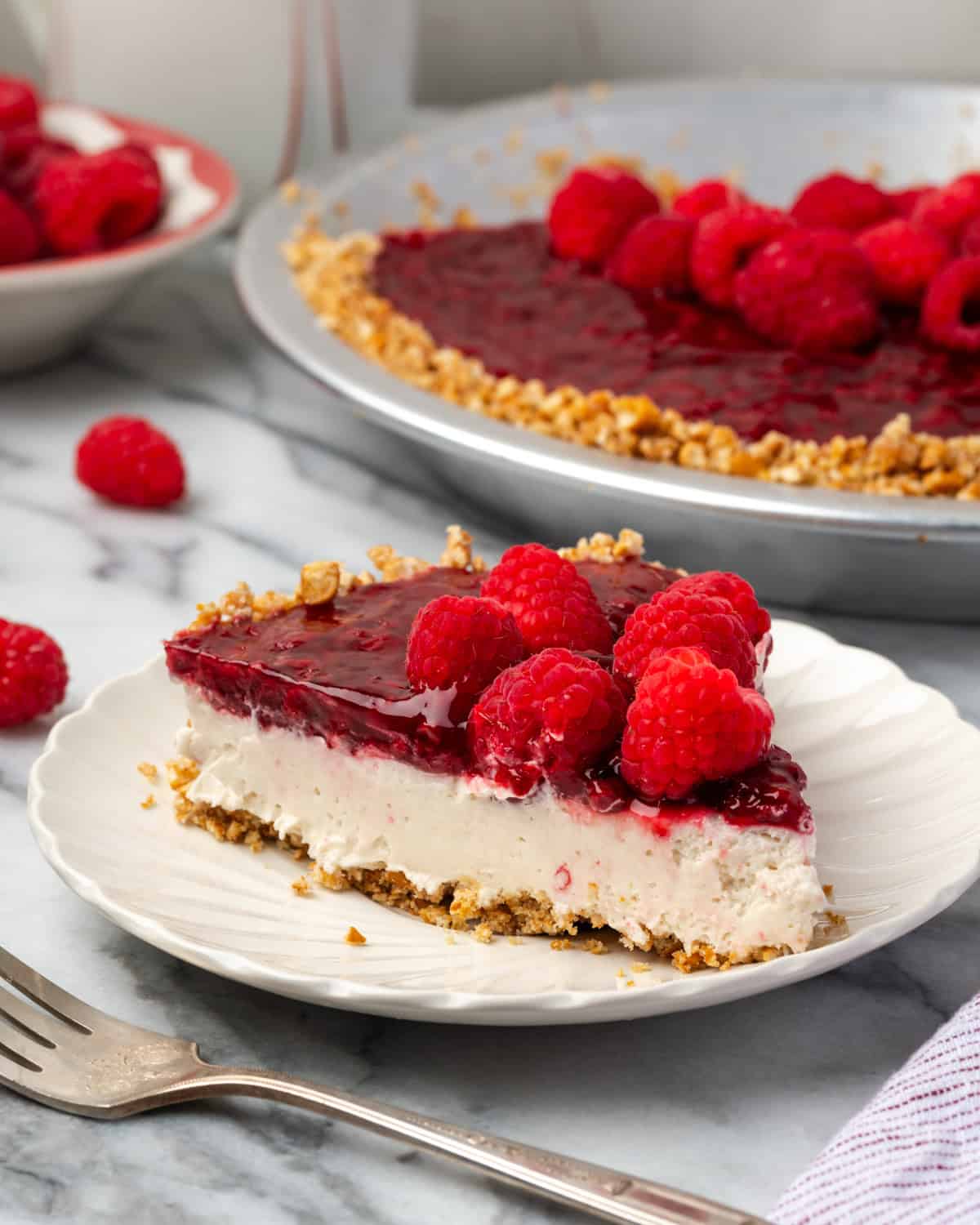 A slice of raspberry cream pie sitting on a small dessert plate.