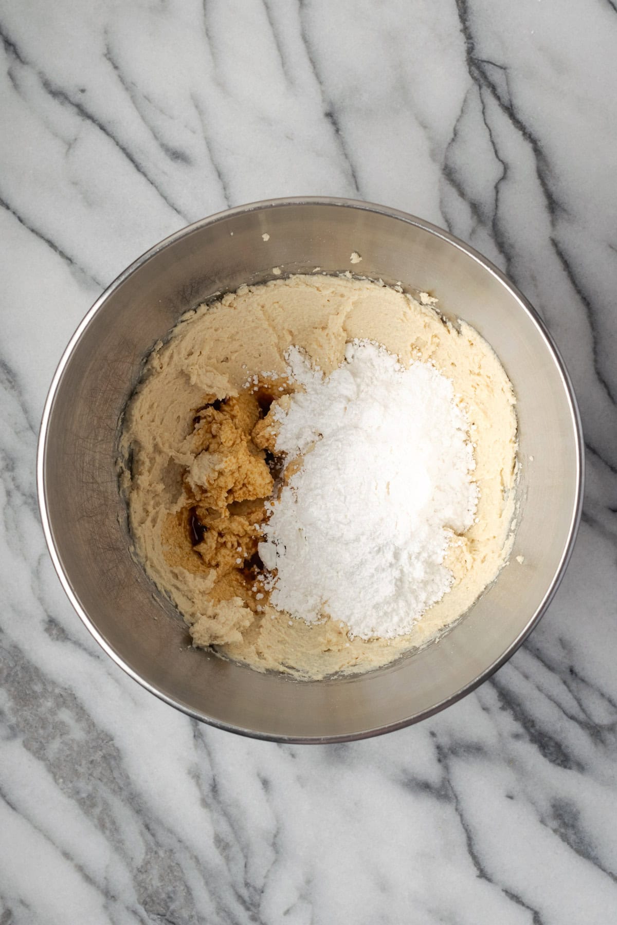 Powdered sugar and vanilla being mixed into the cream cheese. 