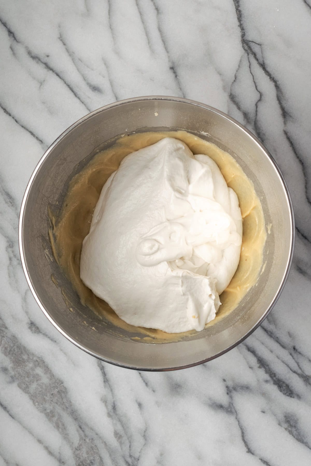 Whipped cream being folded into the cream cheese mixture.