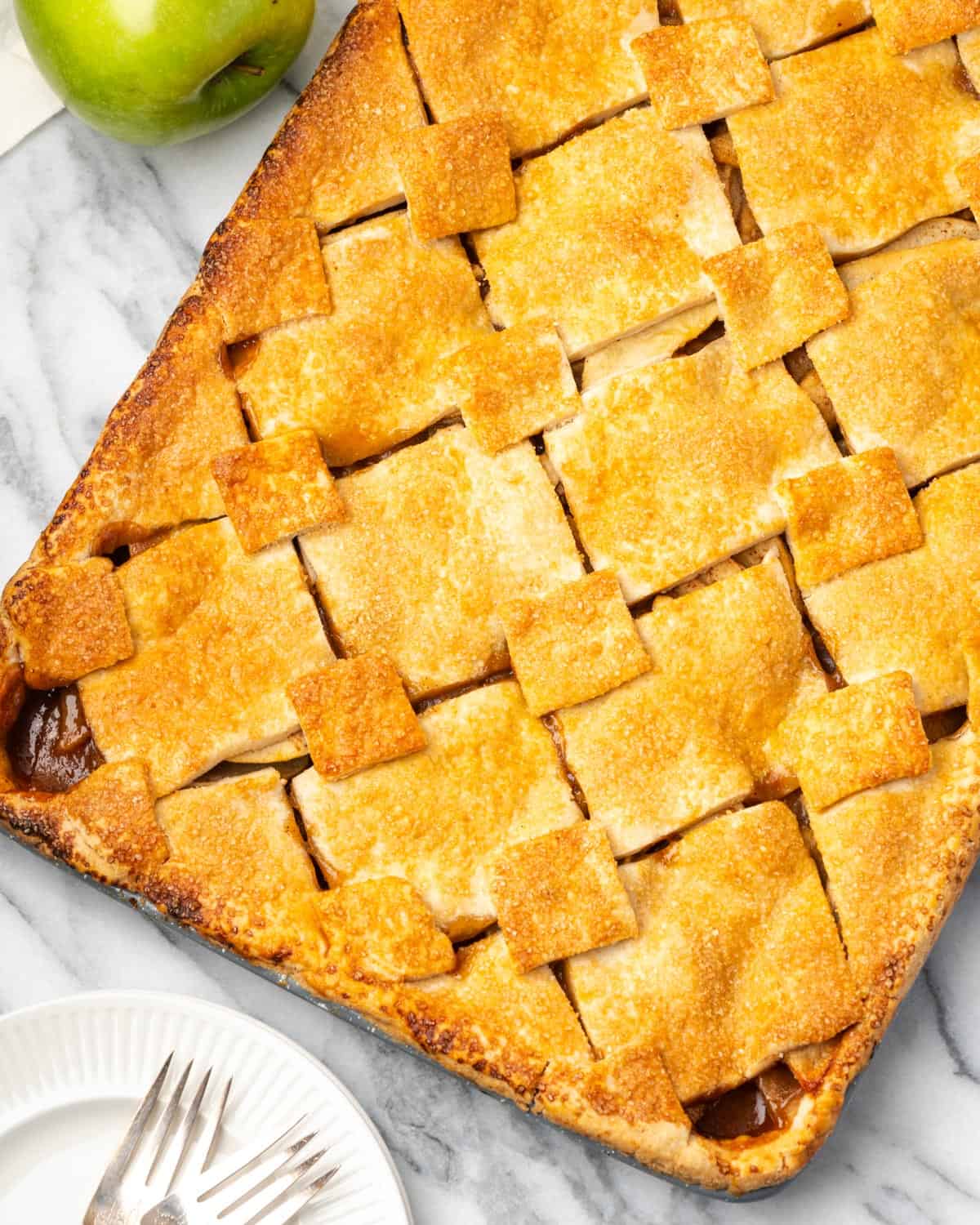 A baked apple slab pie sitting on a marble counter. 