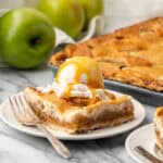 A slice of an apple slab pie topped with ice cream served on a small dessert plate.