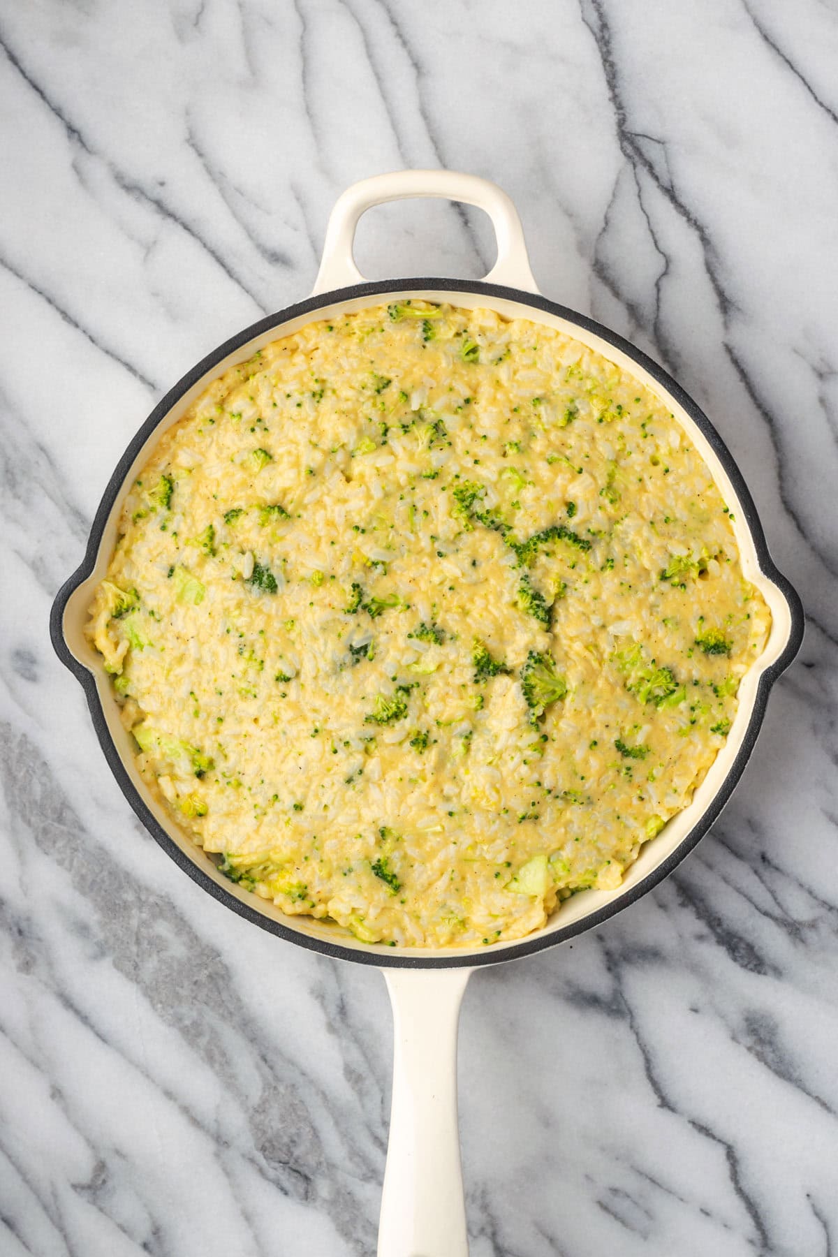 Uncooked broccoli rice casserole in a cast iron skillet. 
