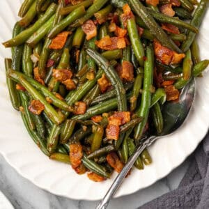 Green beans with bacon and onion on a large serving platter.