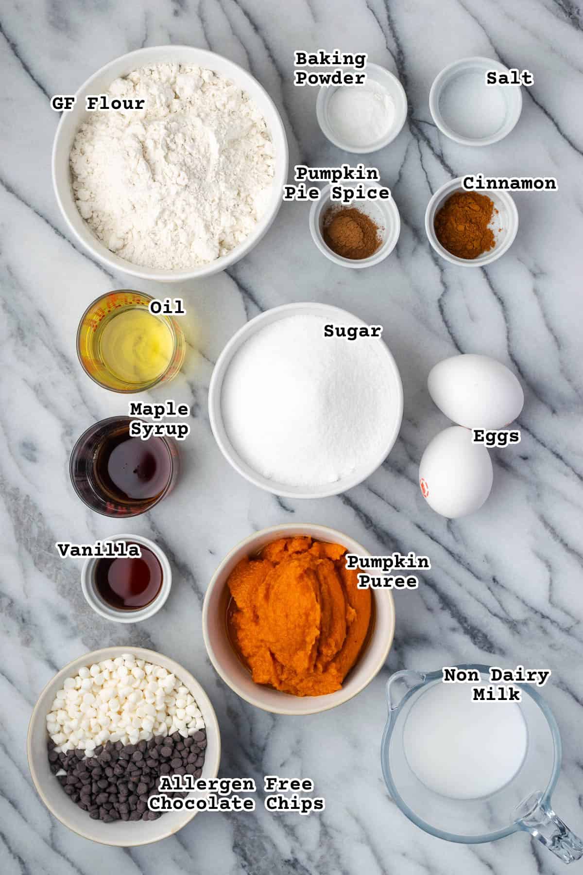 Ingredients for a gluten free pumpkin chocolate chip cake sitting on a marble counter.