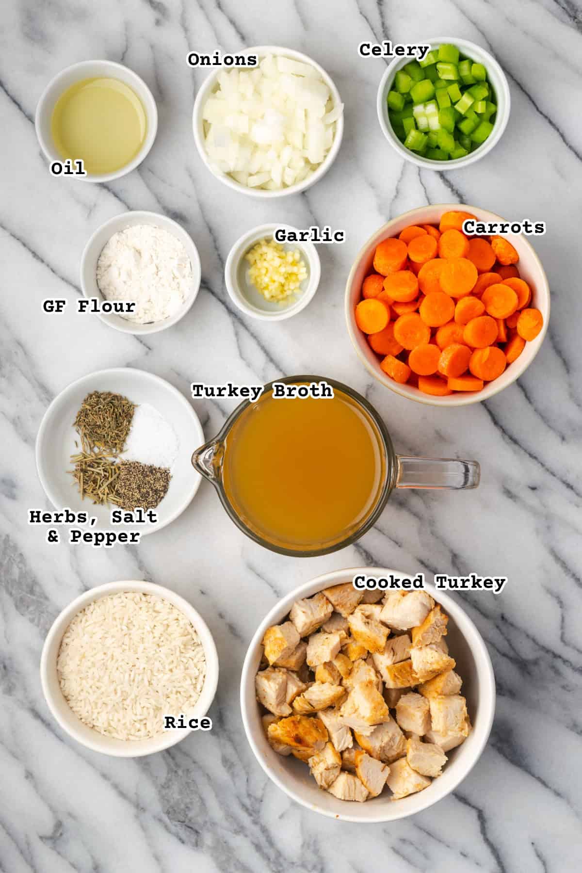 Ingredients for turkey and rice soup sitting on a marble counter.