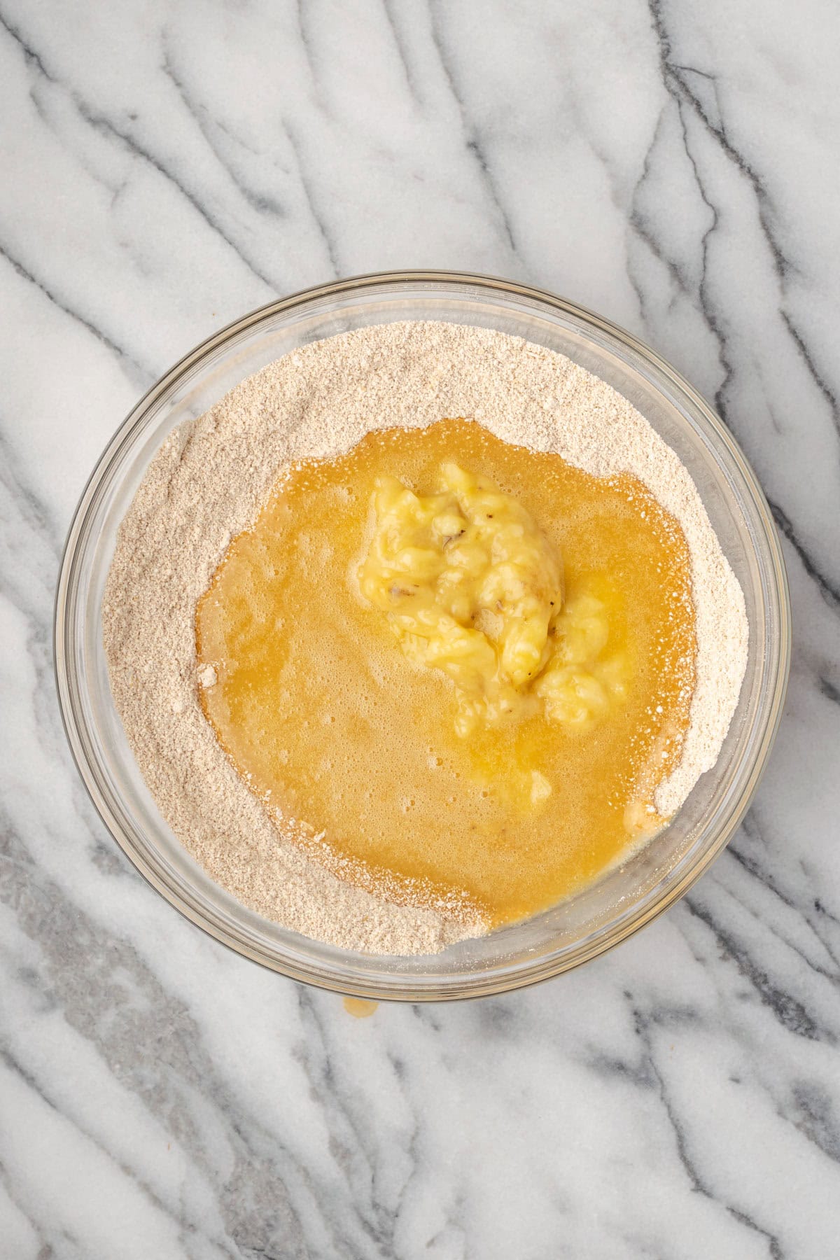 Egg mixture and mashed bananas poured into the bowl with the dry ingredients.
