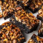 Several pecan pie brownies scattered on a serving tray.